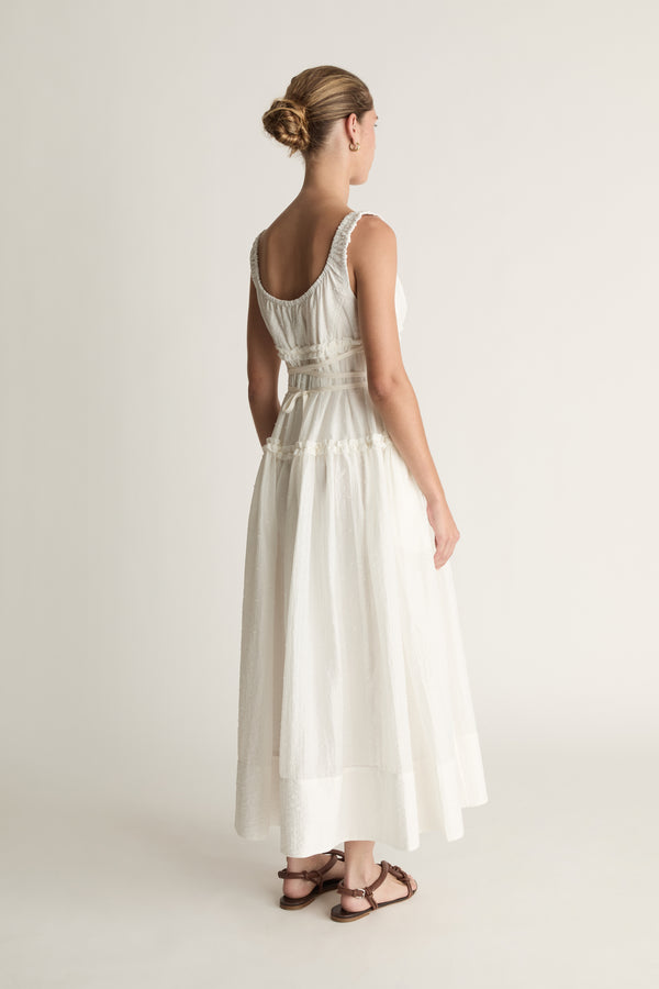 Woman wearing a white dress against a plain background