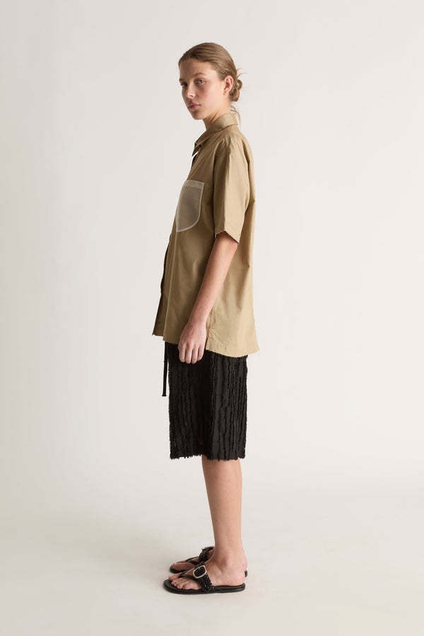 Side view of a camel short-sleeve shirt showing a sheer white chest pocket and relaxed fit.