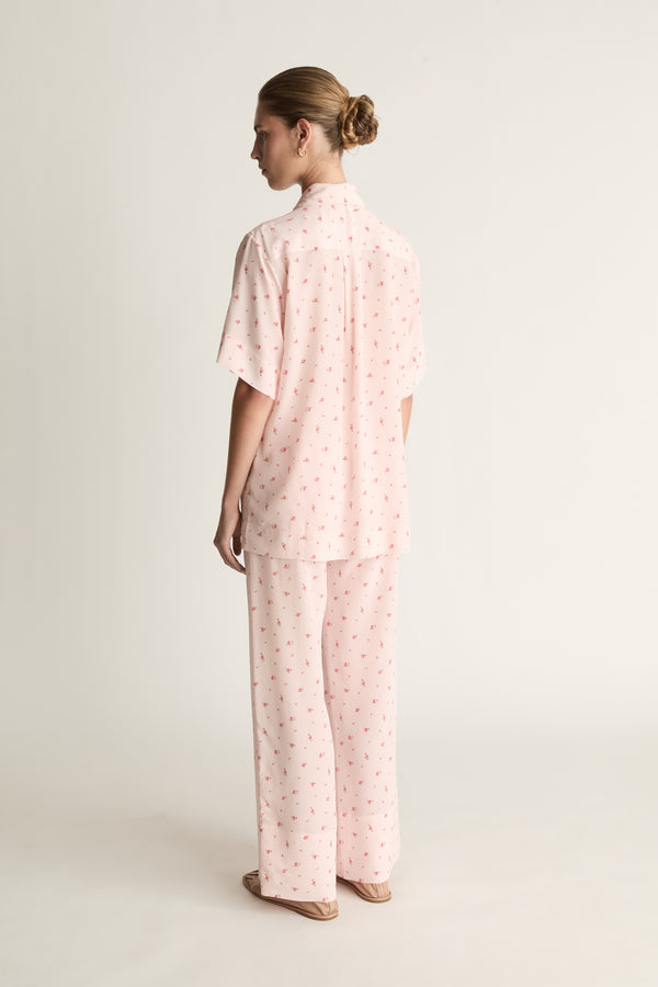 Person wearing pink floral short sleeve shirt and pants set