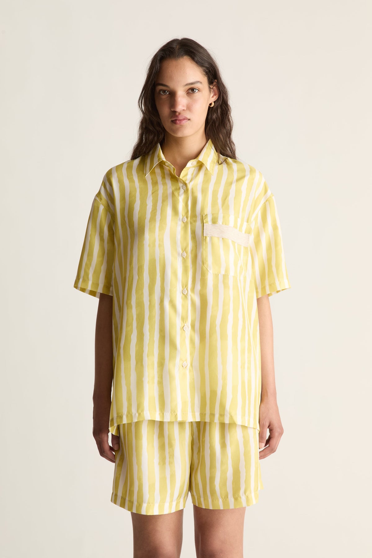 Close-up of a yellow striped silk shirt with chest pocket, camp collar and short sleeves