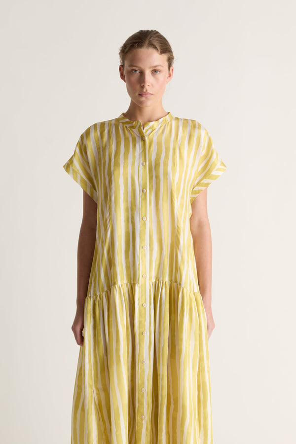 Close-up of a yellow striped silk shirt dress with mandarin collar, button placket and gathered tier