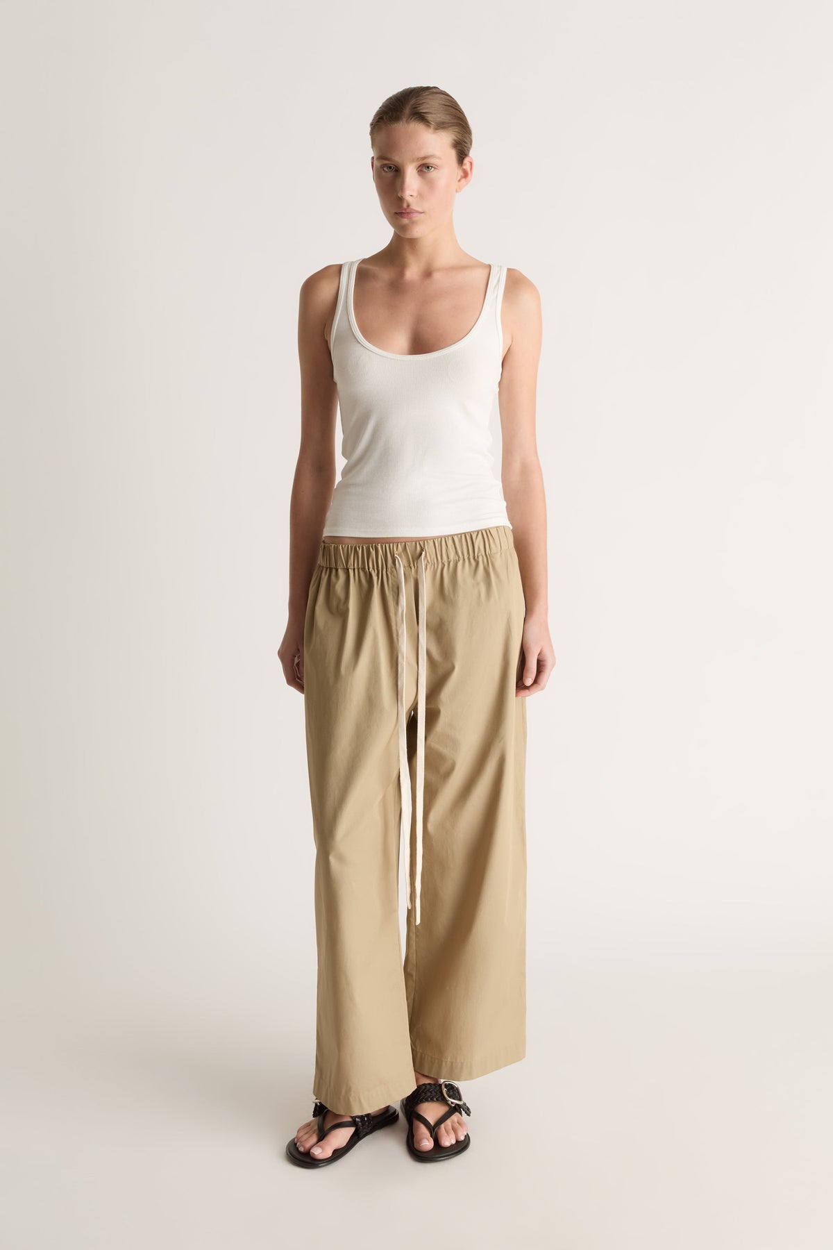 Full-length front view of relaxed camel wide-leg pants with a drawstring waist and ankle-length hem.