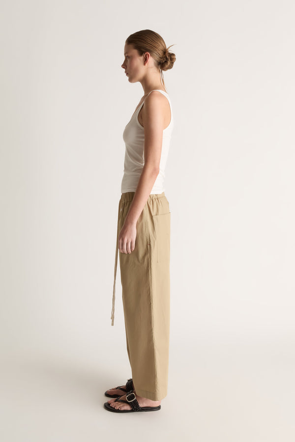 Side view of camel wide-leg pants with an elasticated waist and long hanging drawstring.