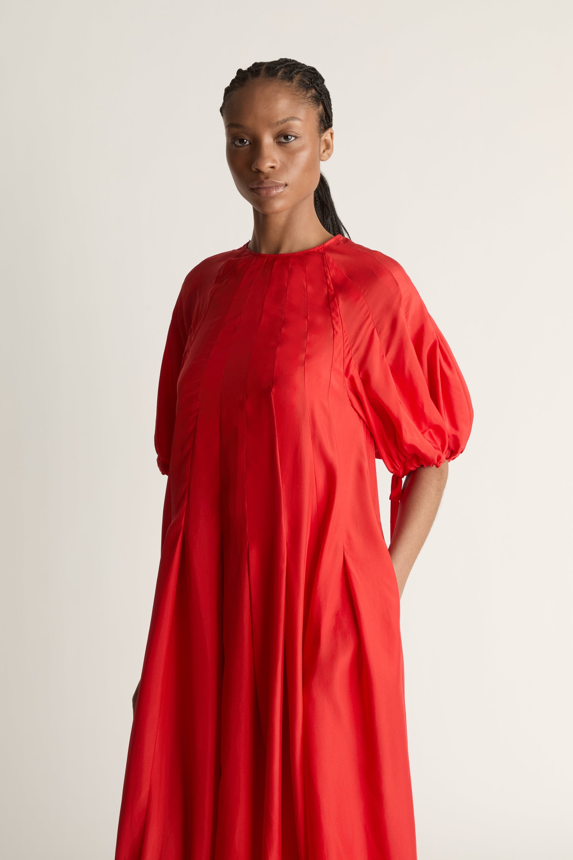 Person wearing a red dress on a white background