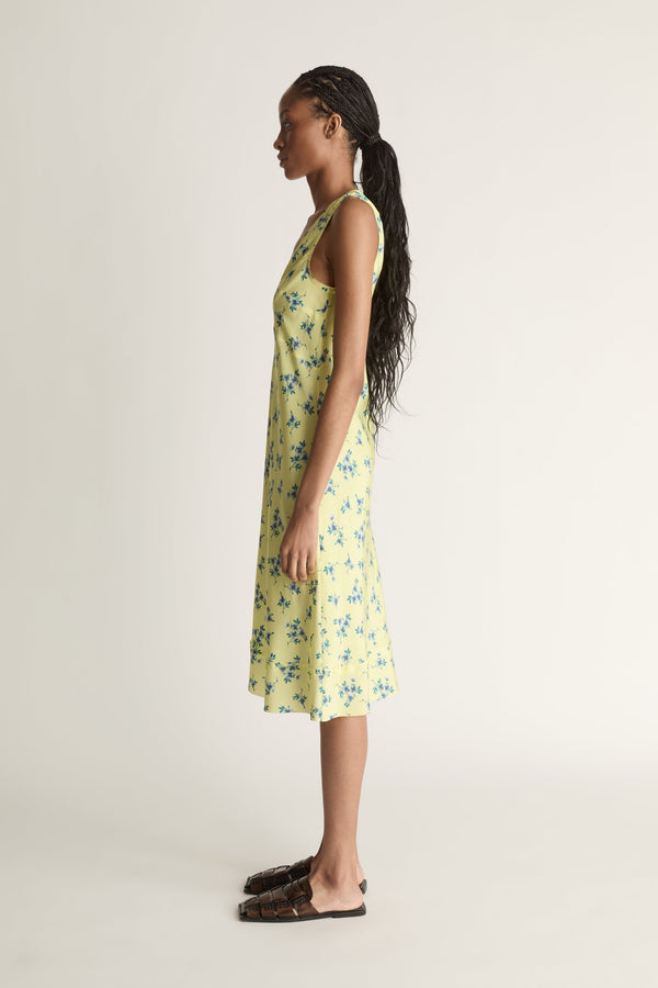 Woman wearing a yellow floral dress on a white background