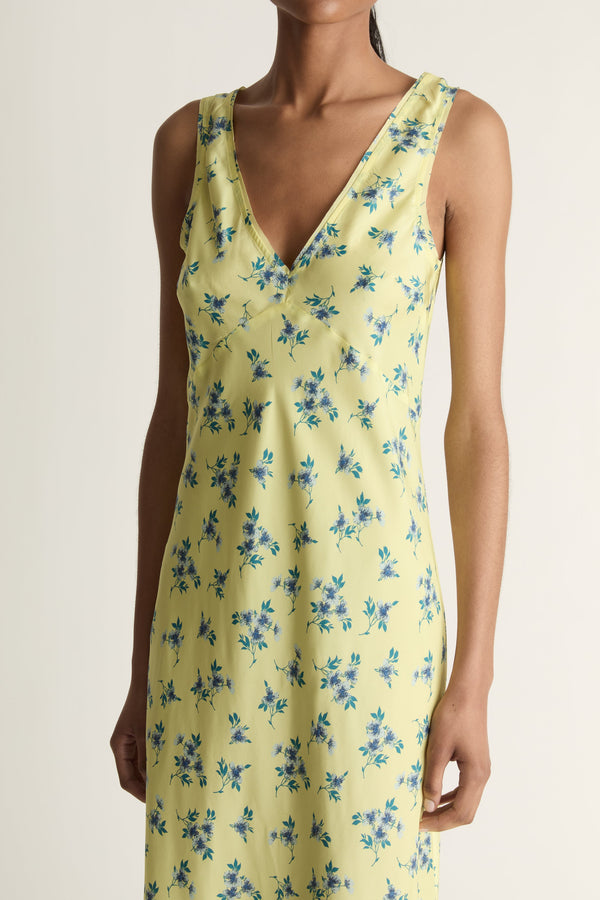 Woman wearing a yellow floral dress on a white background