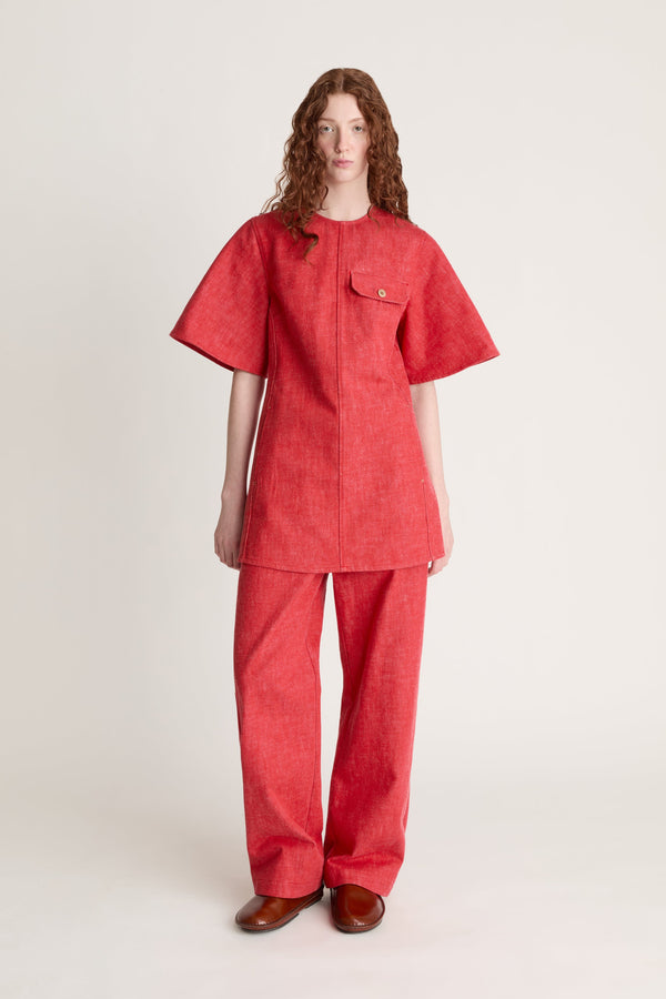 Person wearing a reddress and red pants on a white background
