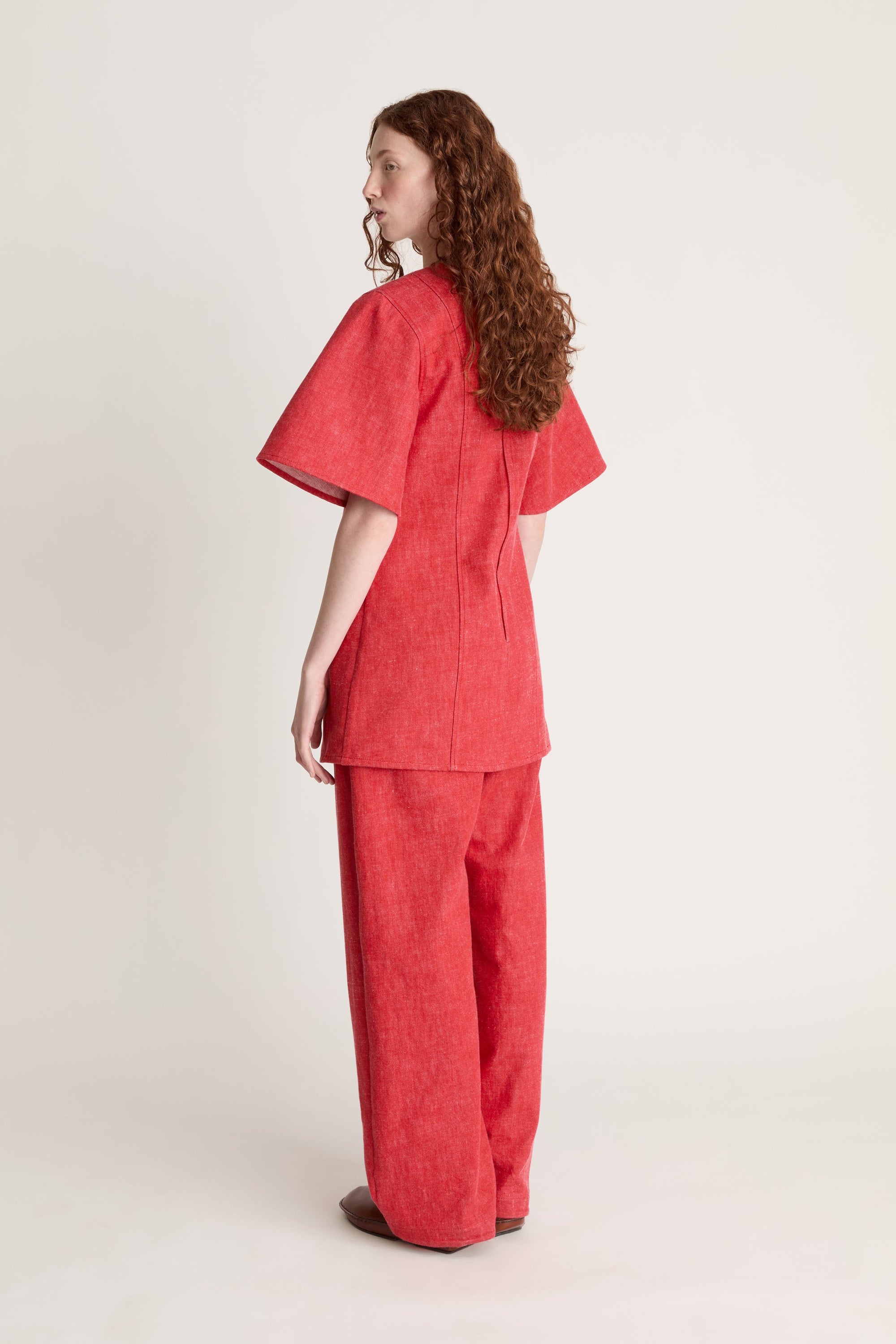 Person wearing a reddress and red pants on a white background