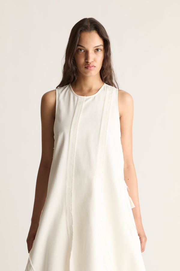 Close-up of a white sleeveless midi dress with round neckline, centre panel seam and curved seams