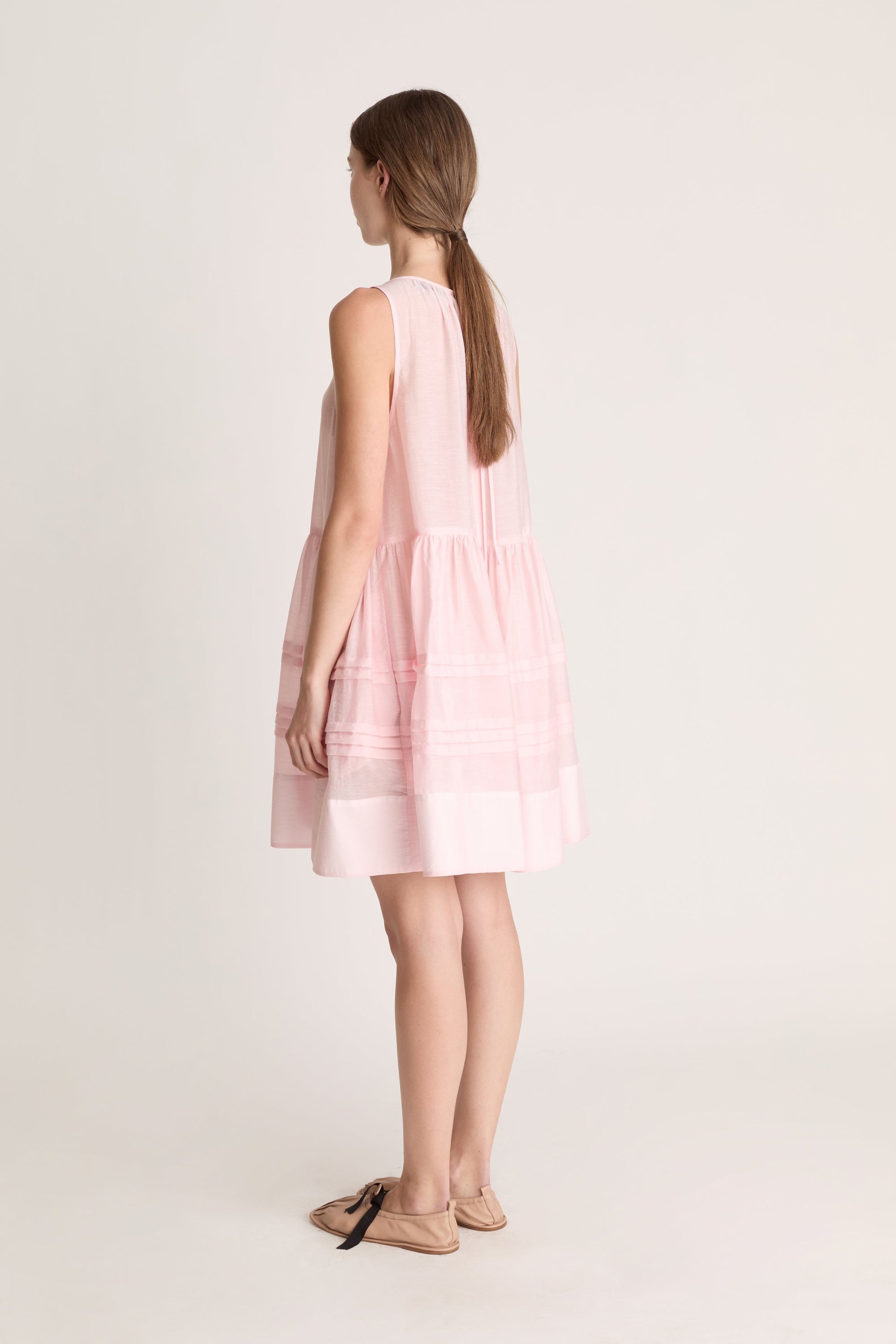 Woman wearing a pink dress against a white background