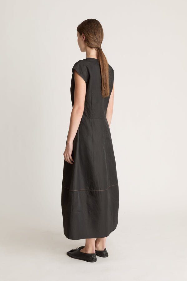 Woman wearing a black  v neck dress on a white background