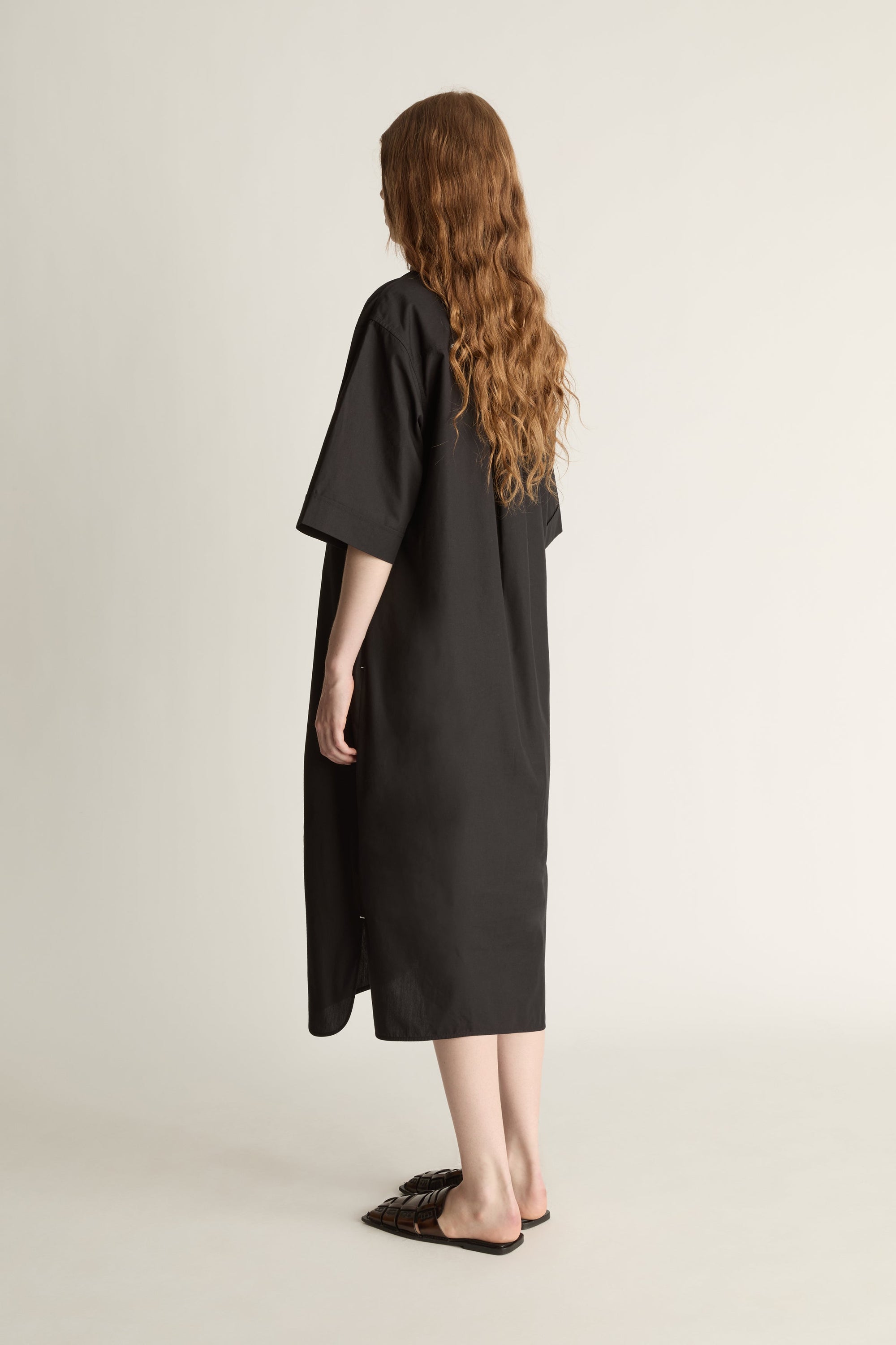 Woman wearing a black dress on a plain background