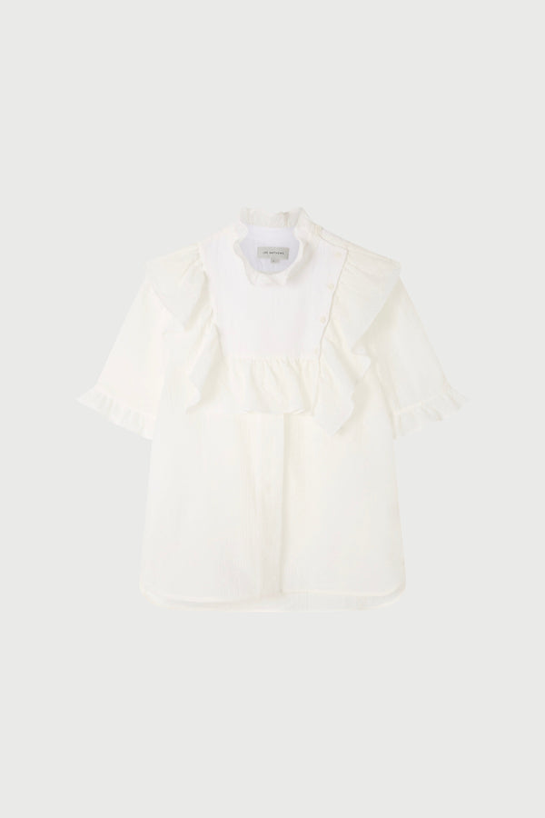 A white top with ruffled sleeves   on a plain background