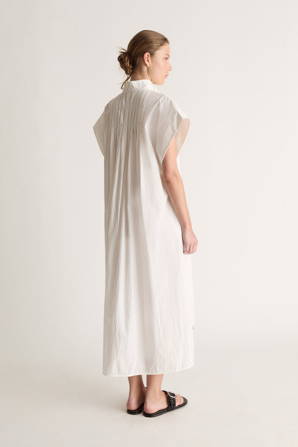 Back view of a white midi shirt dress with pin tucks across the back yoke and wide cap sleeves.