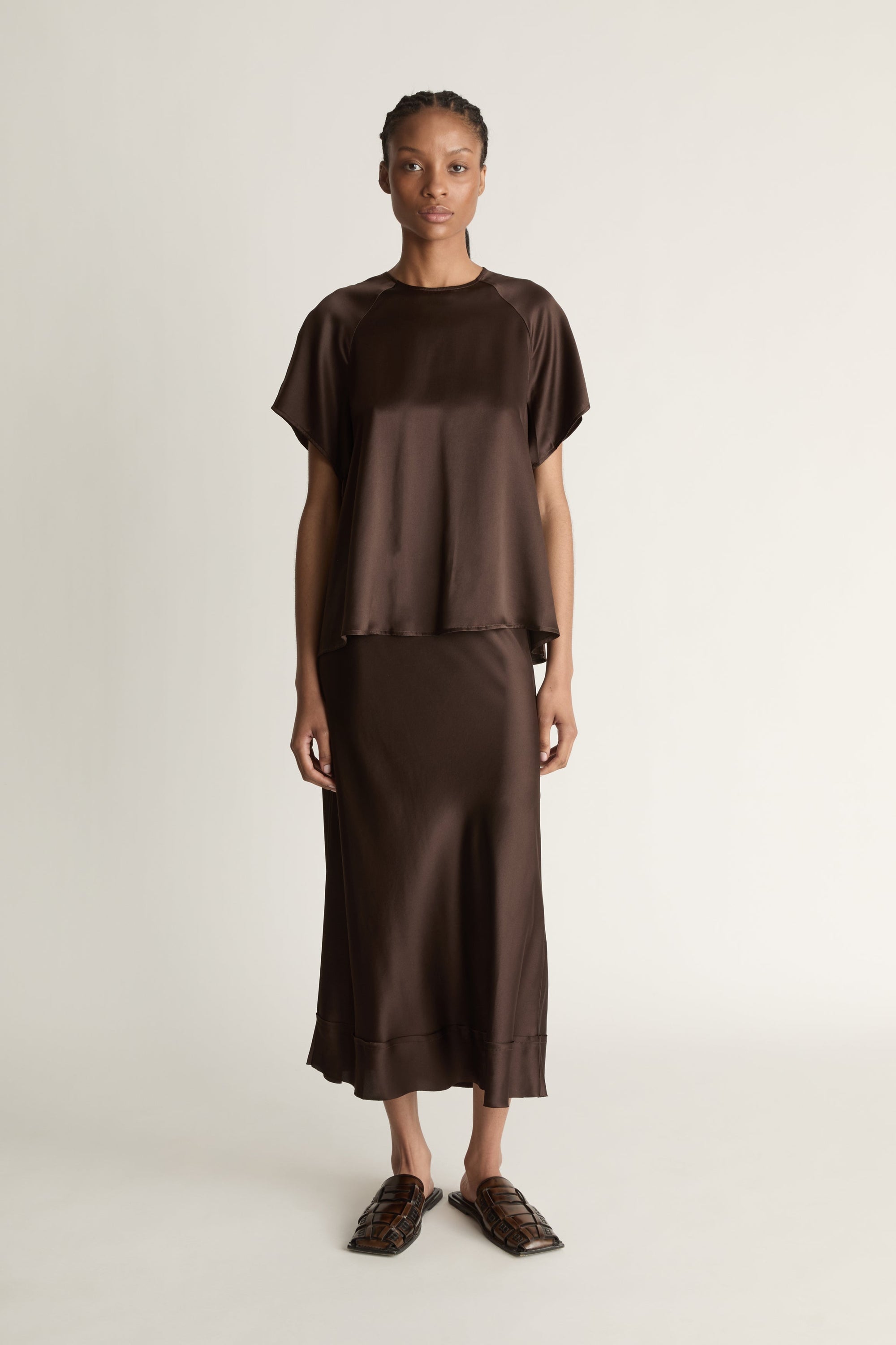 Woman wearing a brown outfit on a plain background