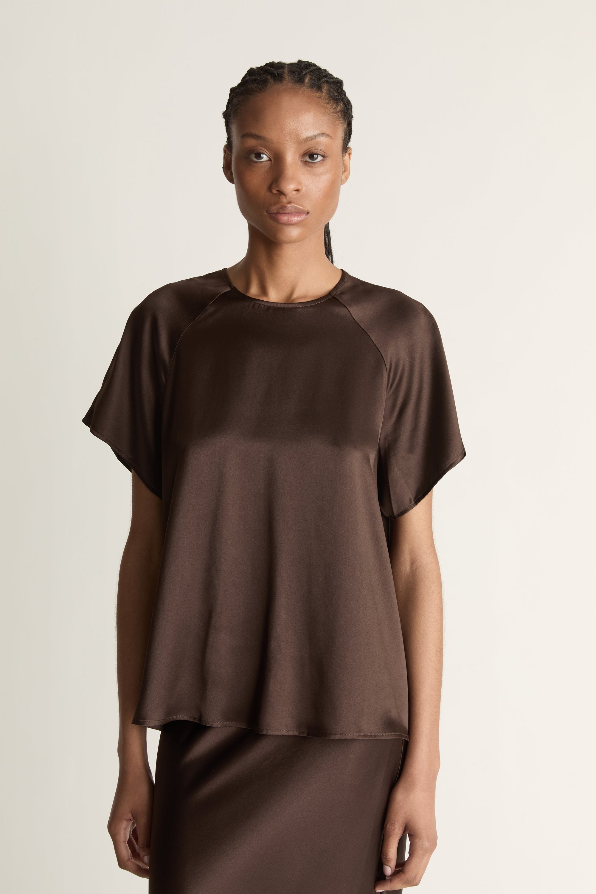Woman wearing a brown outfit on a plain background