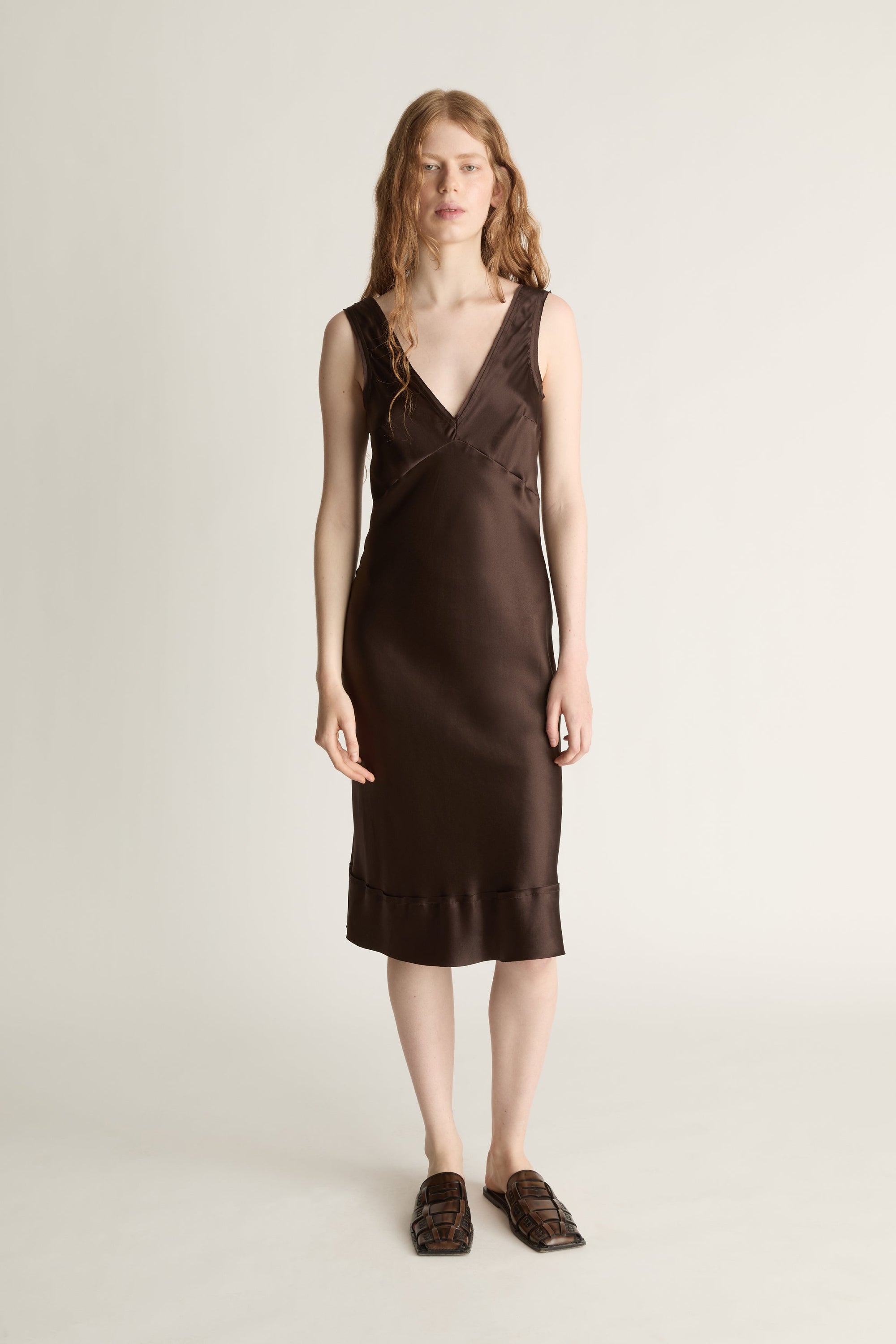 Woman wearing a brown dress on a plain background